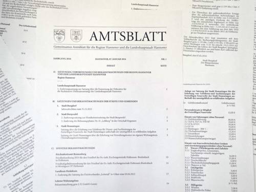 Amtsblatt: Bedruckte Papierbögen liegen neben- und aufeinander, auf dem obersten steht in der Kopfzeile "AMTSBLATT"